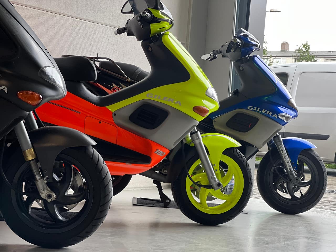 Drie Gilera scooters op een rij in de werkplaats
